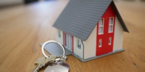 Scaled model of home on a table with key chain in front of it